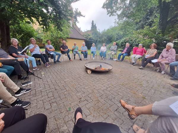 Menschen sitzen gemeinsam ums Feuer