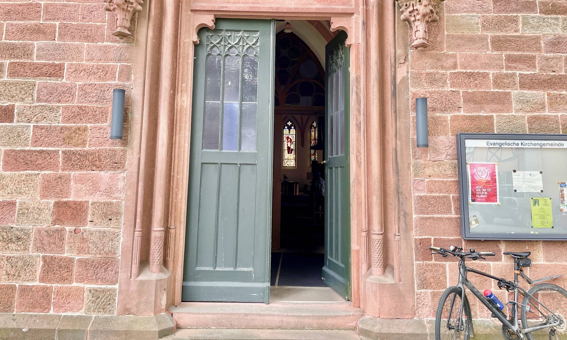 offene Kirchentür mit Fahrrrad